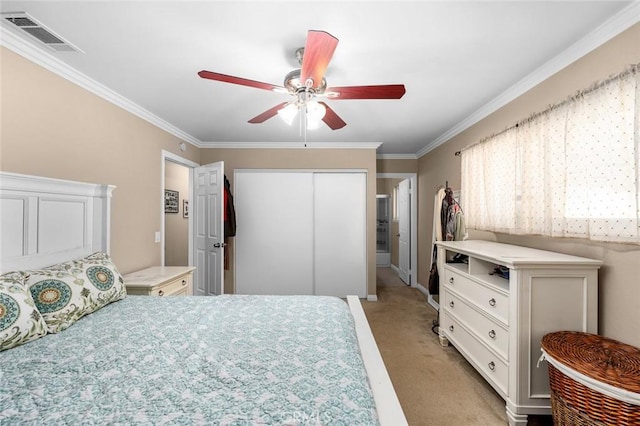 carpeted bedroom featuring a closet, ceiling fan, and ornamental molding