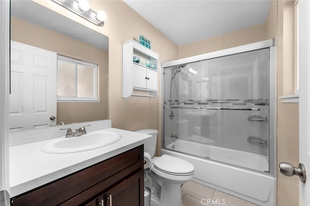 full bathroom with bath / shower combo with glass door, vanity, and toilet