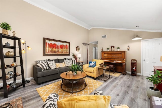 living room featuring hardwood / wood-style floors, vaulted ceiling, and ornamental molding