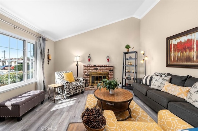 living room with hardwood / wood-style flooring, vaulted ceiling, ornamental molding, and a fireplace