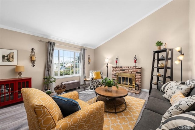 living room with hardwood / wood-style floors, vaulted ceiling, ornamental molding, and a fireplace