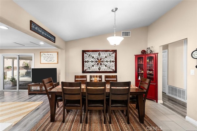 dining space featuring hardwood / wood-style floors and lofted ceiling