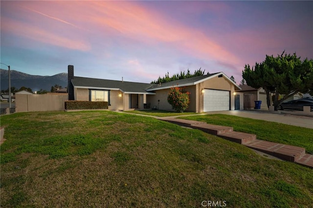 ranch-style home featuring a yard, a mountain view, and a garage