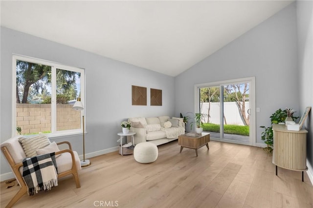 living area with light hardwood / wood-style flooring and high vaulted ceiling