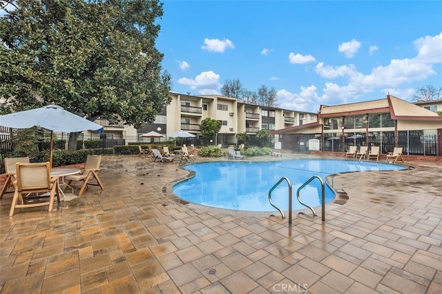 community pool featuring a patio area and fence