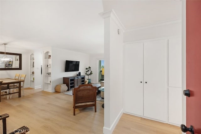 interior space featuring baseboards, an inviting chandelier, wood finished floors, and crown molding