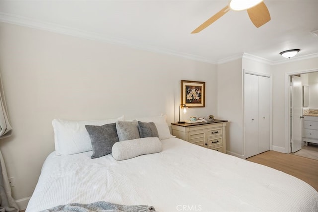 bedroom featuring light wood-style flooring, a ceiling fan, baseboards, ornamental molding, and a closet