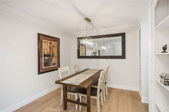 dining area with ornamental molding, light wood finished floors, and baseboards