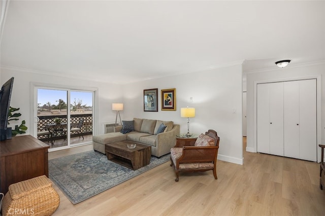 living room with light wood-style floors, baseboards, and ornamental molding