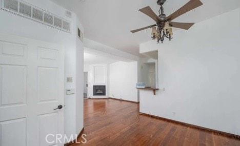 unfurnished living room with dark hardwood / wood-style floors and ceiling fan