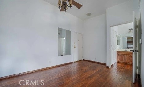 unfurnished bedroom featuring dark wood-type flooring and ensuite bathroom