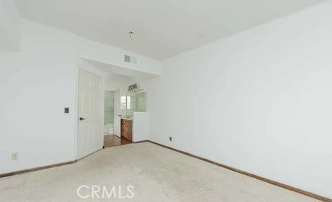 unfurnished bedroom featuring carpet and connected bathroom