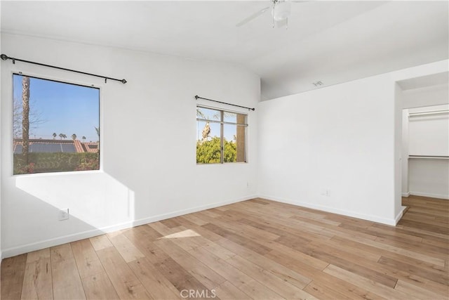 empty room featuring lofted ceiling, ceiling fan, and light hardwood / wood-style flooring