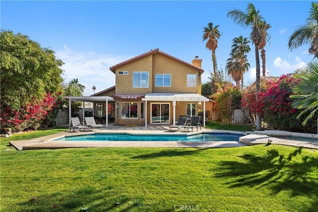 back of house with a yard and a patio