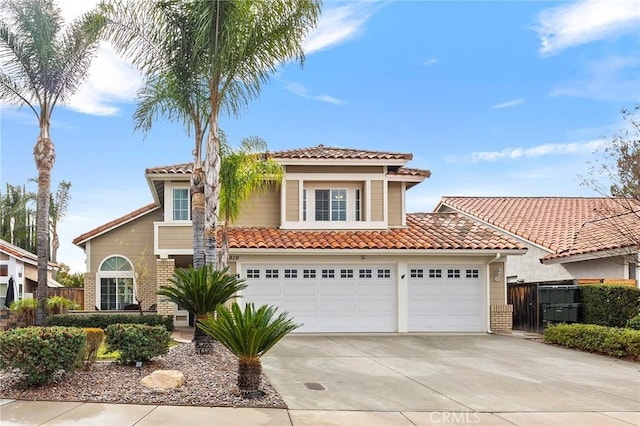 mediterranean / spanish-style home featuring driveway, brick siding, fence, and a tiled roof