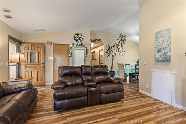 living room featuring radiator heating unit, lofted ceiling, and wood-type flooring