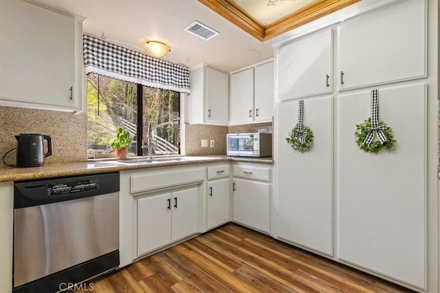 kitchen with stainless steel dishwasher, sink, white cabinetry, and hardwood / wood-style flooring