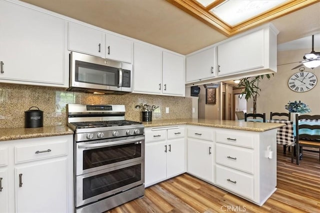 616 Jackson Dr, Paso Robles, CA 93446 - kitchen featuring stainless steel appliances, light wood finished floors, decorative backsplash, and white cabinets