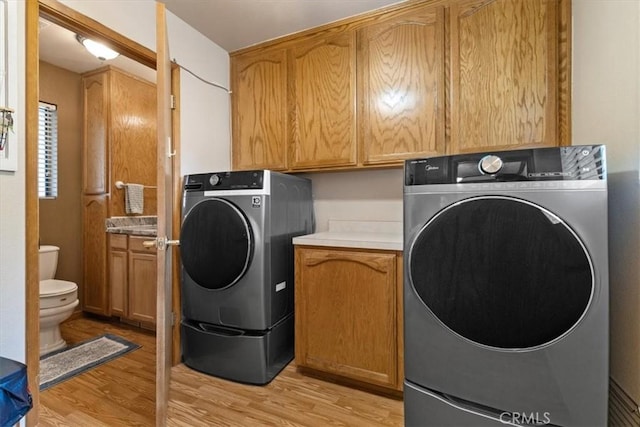 616 Jackson Dr, Paso Robles, CA 93446 - laundry room featuring light wood-style flooring, washer and clothes dryer, and cabinet space