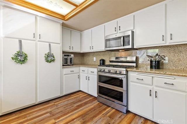 616 Jackson Dr, Paso Robles, CA 93446 - kitchen with stainless steel appliances, white cabinetry, decorative backsplash, and light wood-style floors