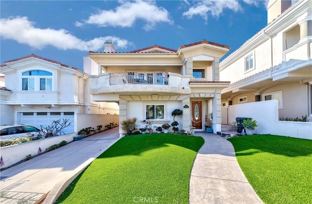 view of front of home featuring a garage, a front yard, and a balcony