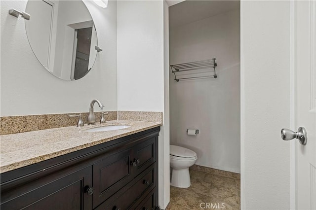 bathroom featuring toilet, vanity, and tile patterned flooring