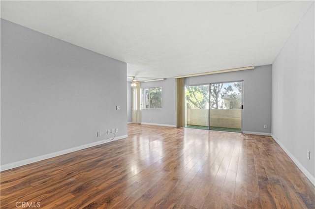 spare room with ceiling fan, baseboards, and hardwood / wood-style floors