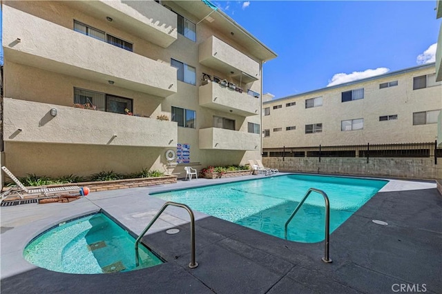 community pool with a patio and fence