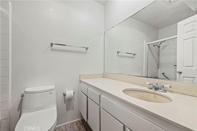 full bath with vanity, a shower stall, toilet, and wood finished floors
