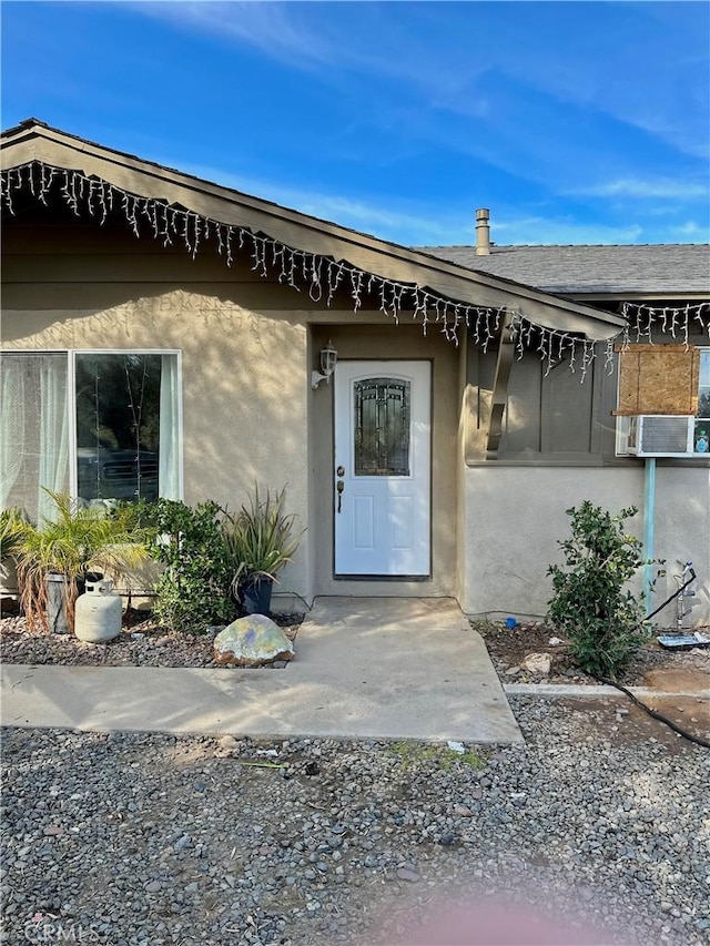 view of exterior entry featuring a patio and cooling unit