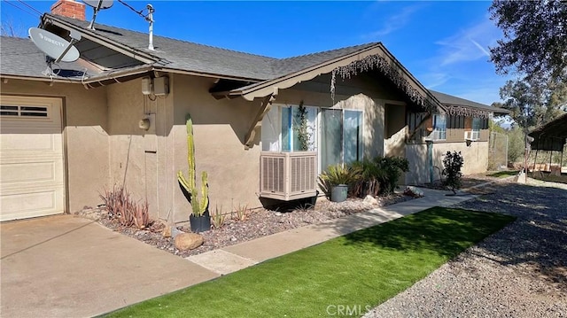 view of side of property with an attached garage and stucco siding