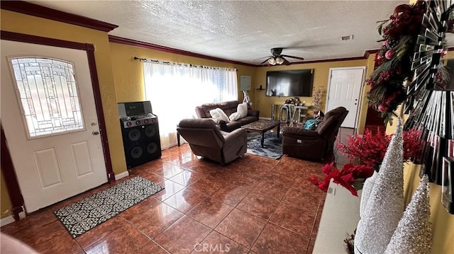 tiled living area featuring visible vents, baseboards, ornamental molding, a ceiling fan, and a textured ceiling