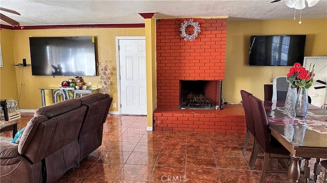 tiled living area with a textured ceiling, a ceiling fan, baseboards, and a fireplace