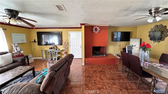 living room featuring dark tile patterned flooring, a brick fireplace, visible vents, and ceiling fan