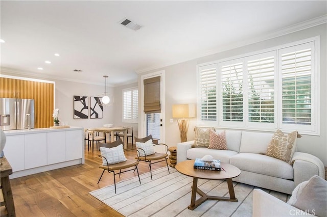 living room featuring crown molding and light wood-type flooring