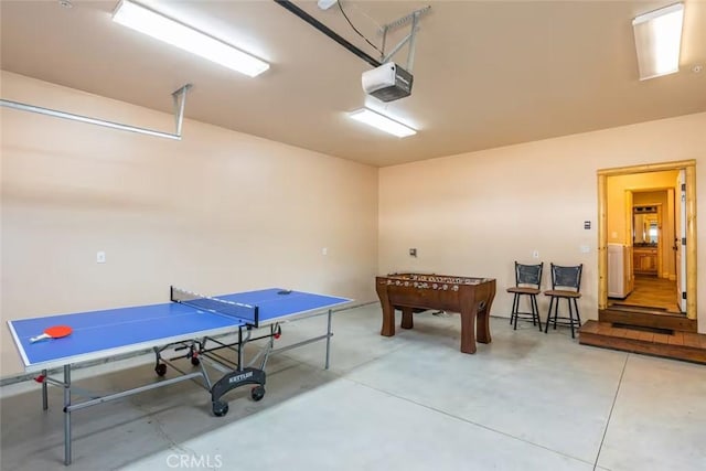 rec room with a garage and finished concrete floors