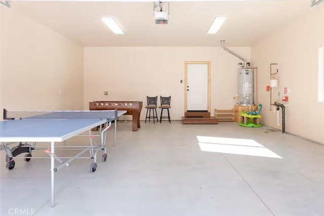 recreation room featuring water heater and concrete flooring