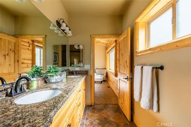 full bathroom featuring double vanity, a sink, and stone finish floor