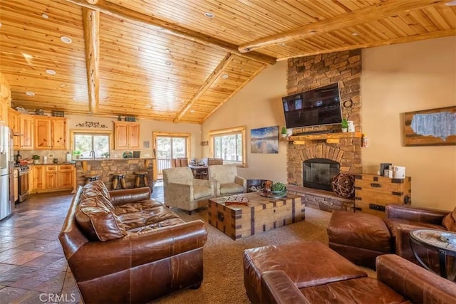 living area with beamed ceiling, high vaulted ceiling, wood ceiling, and a fireplace