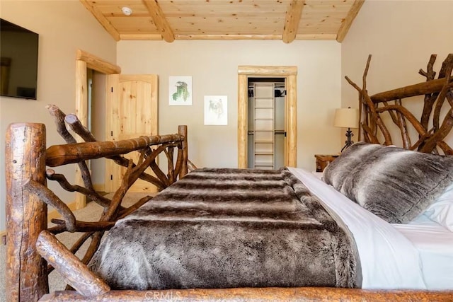 bedroom with lofted ceiling with beams and wooden ceiling