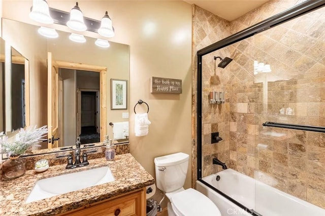 bathroom with toilet, vanity, and shower / bath combination with glass door