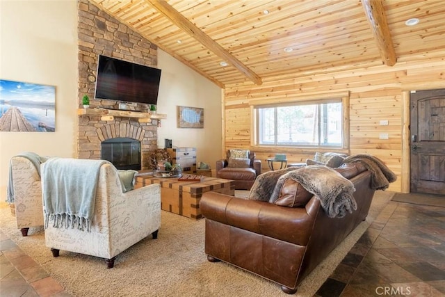 living room with a fireplace, stone tile flooring, wood ceiling, and beam ceiling