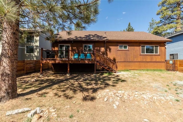 rear view of property with stairs, a shingled roof, a deck, and fence