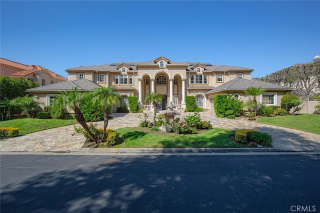 mediterranean / spanish-style house with solar panels and a front lawn