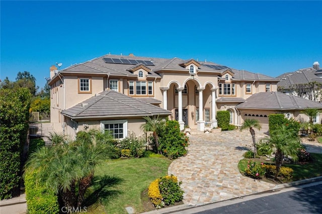 view of front of property featuring solar panels, a front yard, and a garage