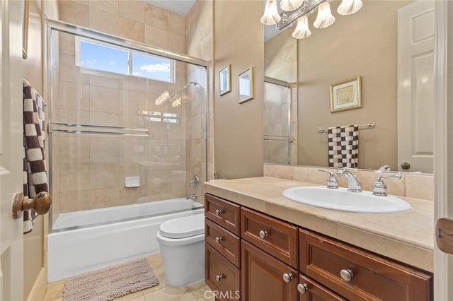 full bathroom with tile patterned floors, toilet, vanity, and bath / shower combo with glass door