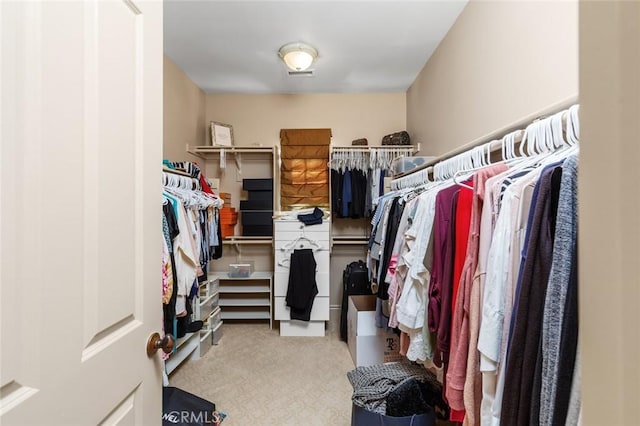 walk in closet featuring light colored carpet