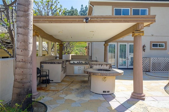 view of patio / terrace featuring an outdoor kitchen, grilling area, and a fire pit