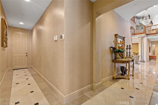 corridor with decorative columns and a chandelier