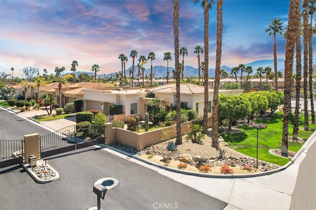 3 Mesquite Ridge Ln, Rancho Mirage, CA 92270 - view of front facade with driveway, a gate, a garage, fence, and a mountain view
